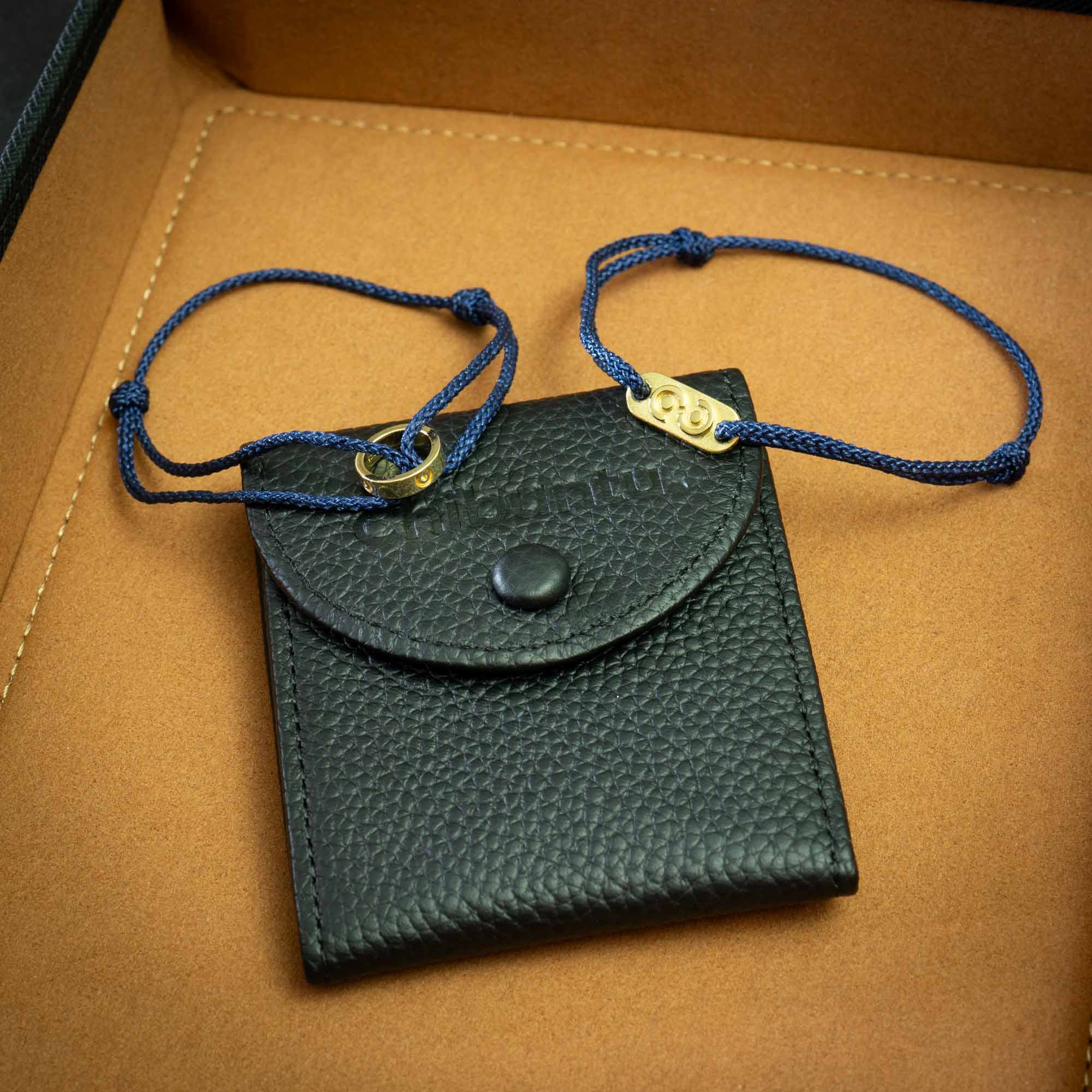 Navy blue 14k gold plated ring bracelet and tag bracelet alongside a premium genuine leather bracelet pouch, displayed in a box.