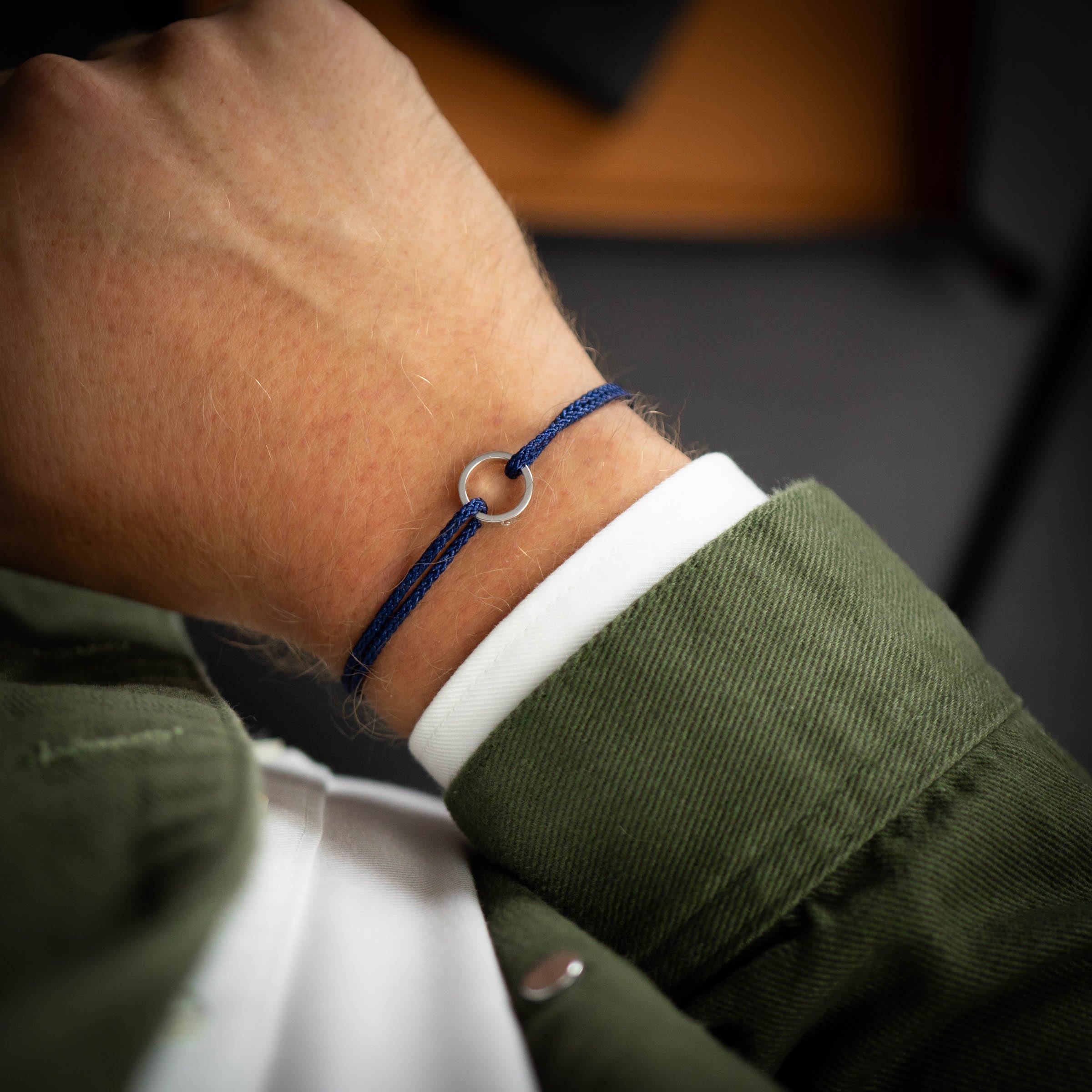 silver ring bracelet on blue thread