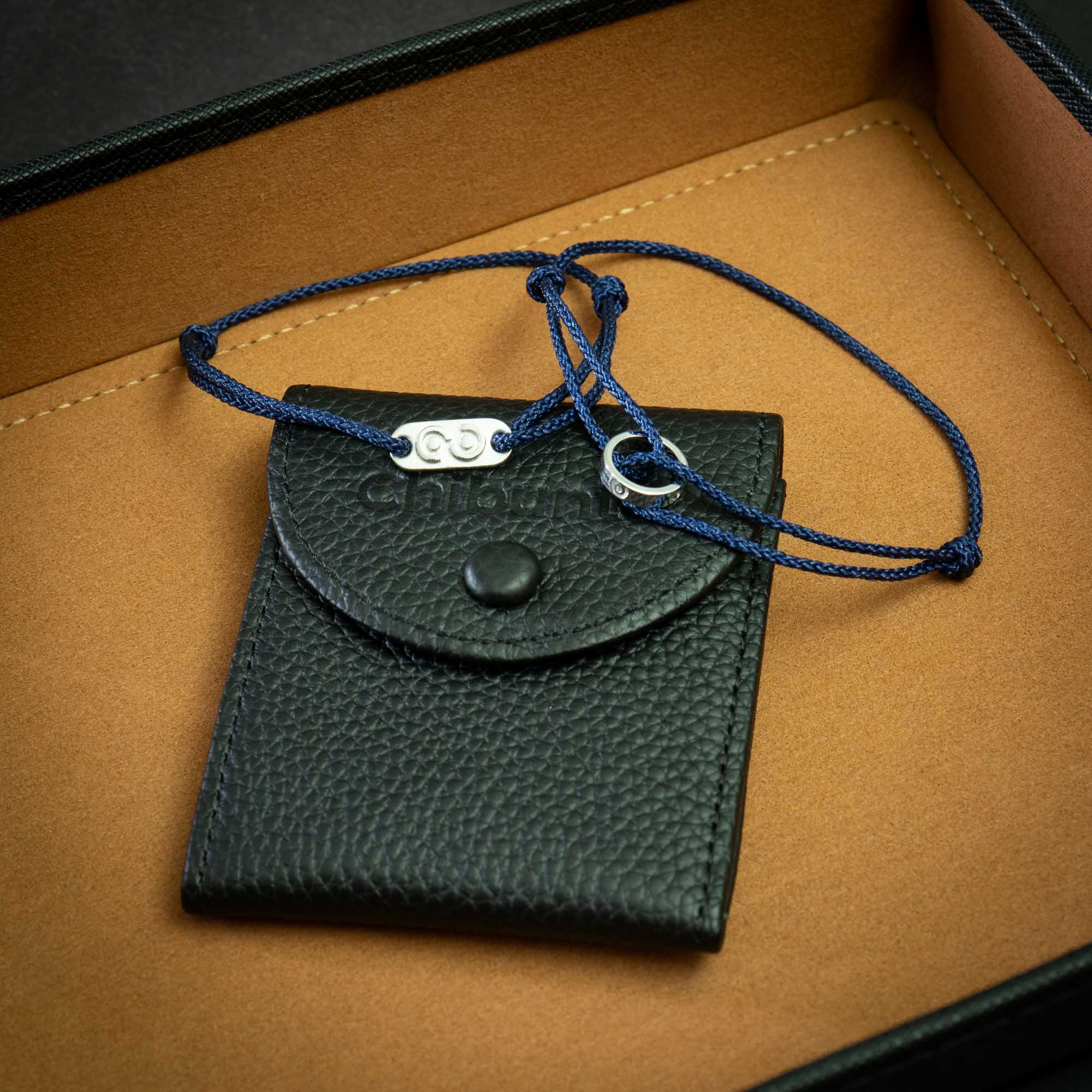 Navy blue 925 silver jewelry set displayed on a brown surface, including a ring bracelet, a tag bracelet, and a leather bracelet pouch with a silver polish cloth.