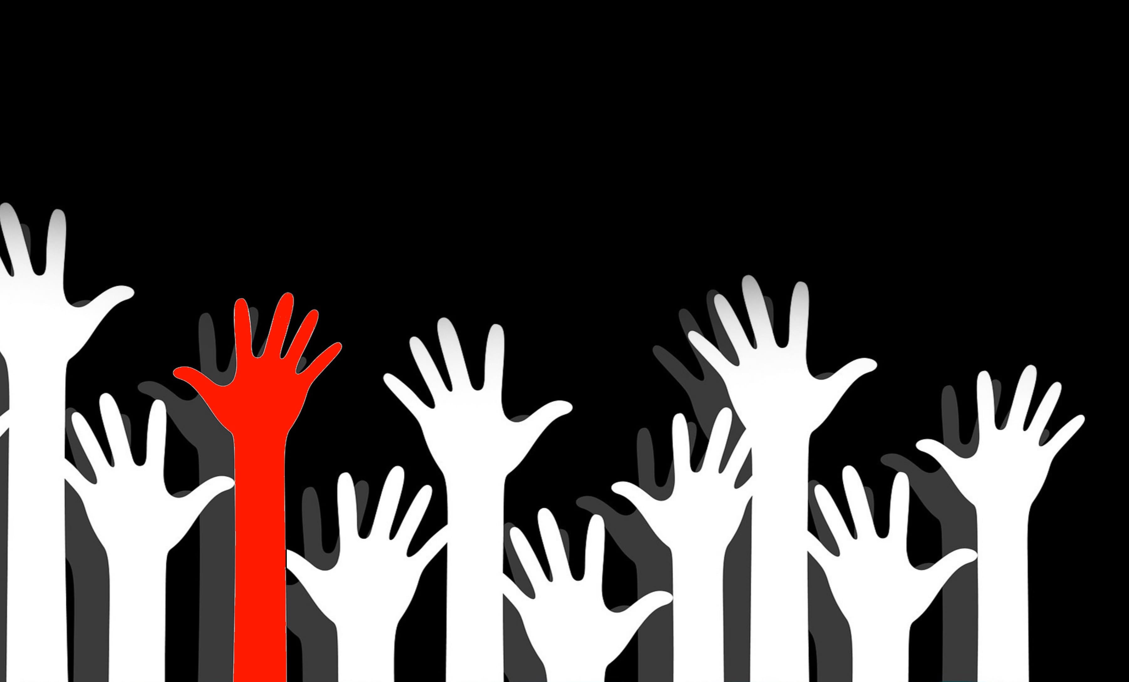 Red hand raised above white hands on a black background for our charity bracelets