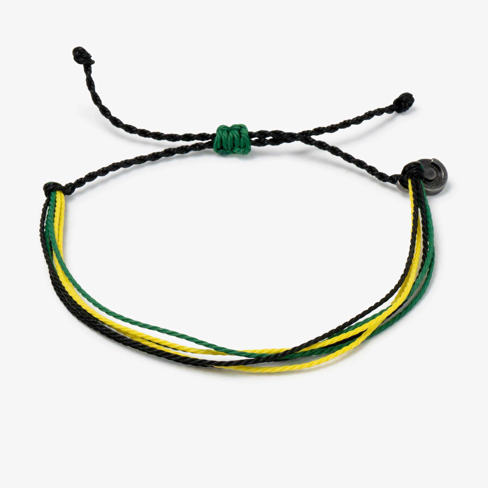 A bracelet with black, green, and yellow strings, featuring a gunmetal power pose charm.