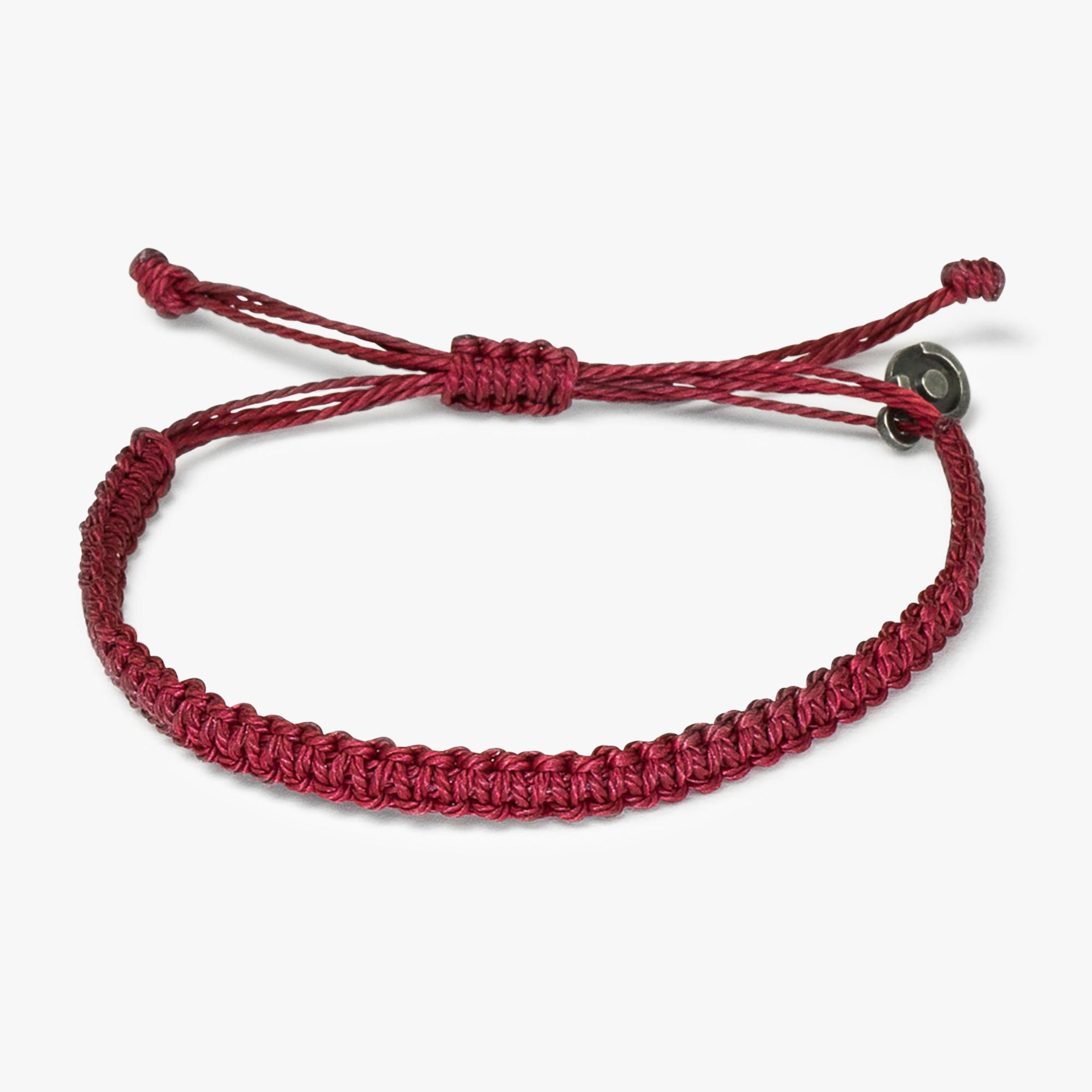 A red woven bracelet with a gunmetal charm, displayed on a white background.