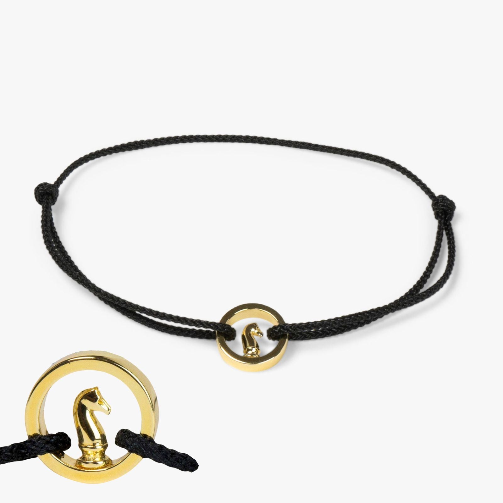 A black bracelet with a gold-plated ring and a silver polish cloth on a white background.