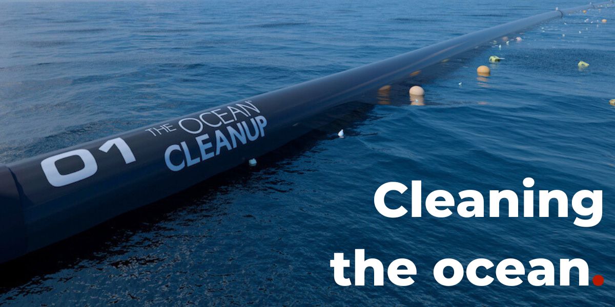 Long black structure with 'The Ocean Cleanup' branding on a blue ocean background.
