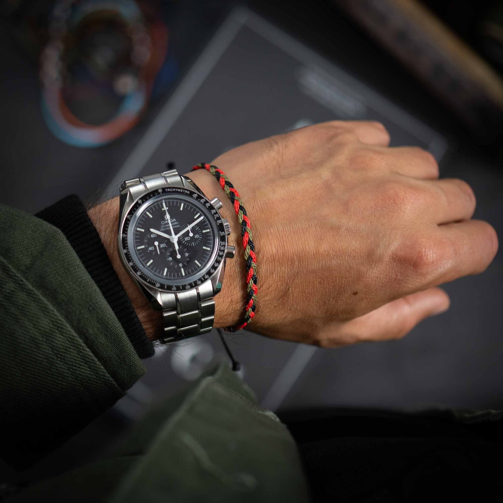 red green flow bracelet for men next to omega speedmaster