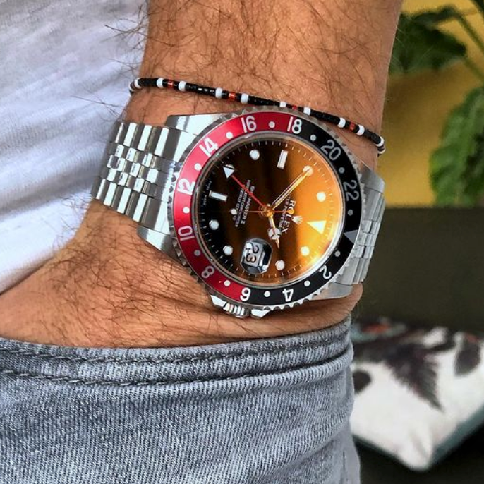 black bracelet next to rolex gmt coke