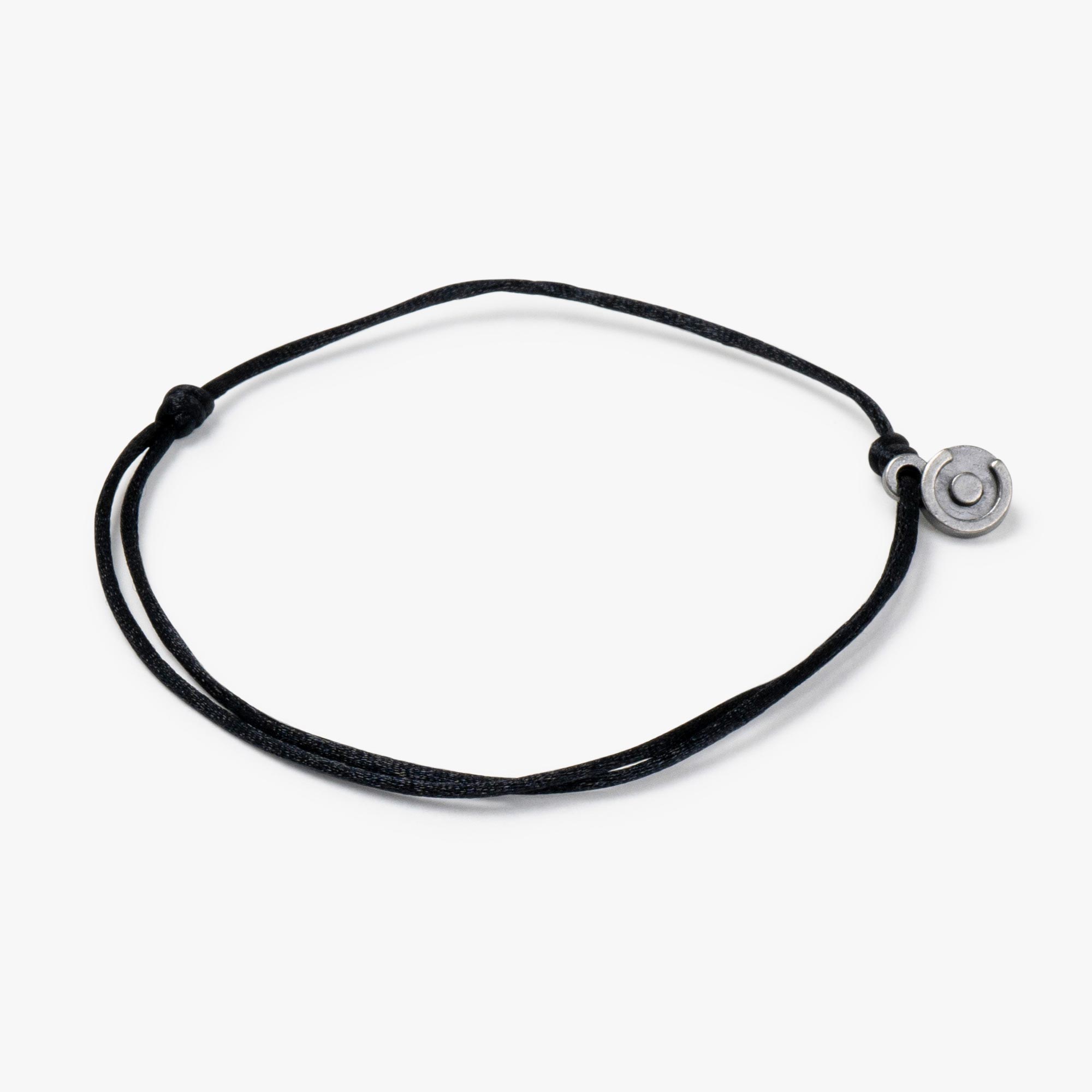 A black satin bracelet with a gunmetal power pose charm, displayed against a white background.