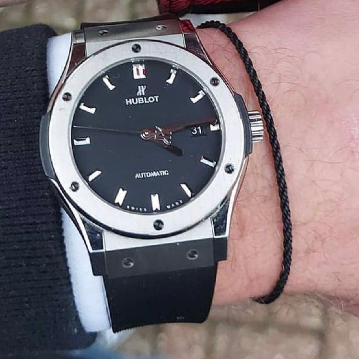 black bracelet next to hublot