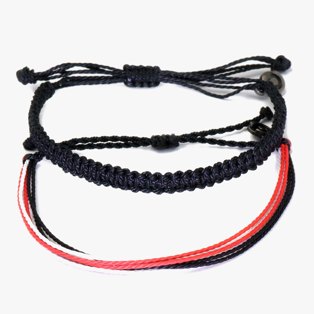 Two wax-coated polyester bali bracelets, one black and one red, with gunmetal power pose charms, displayed against a white background.