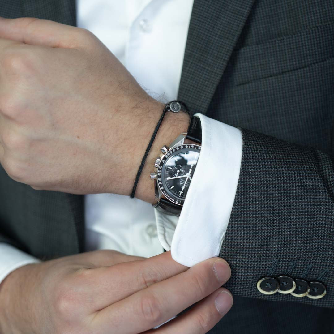 black cotton bracelet for watchlovers next to omega speedmaster