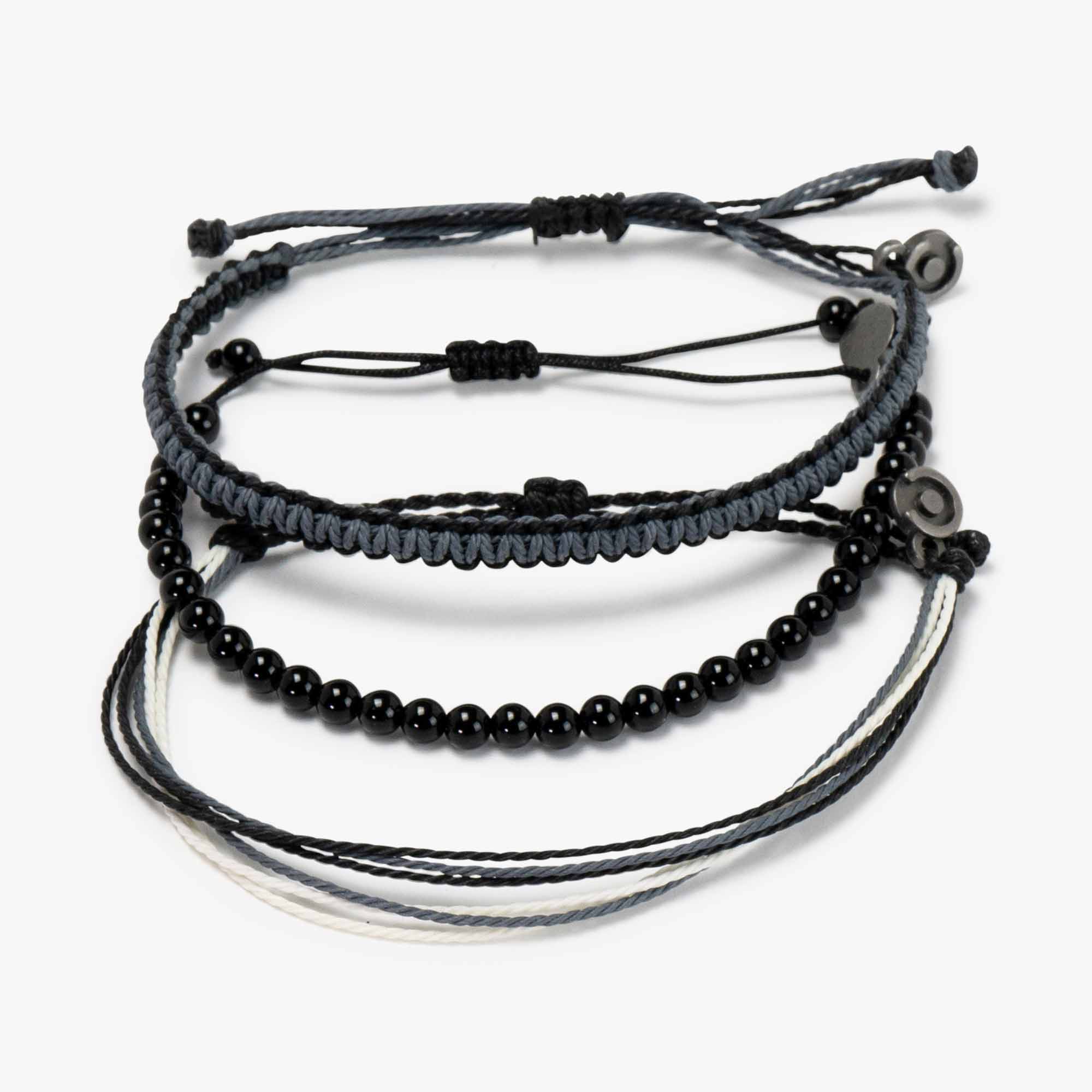 A set of bracelets featuring black onyx gemstone combined with two James Bond-themed waxed-coated polyester bracelets, including a gunmetal power pose charm.