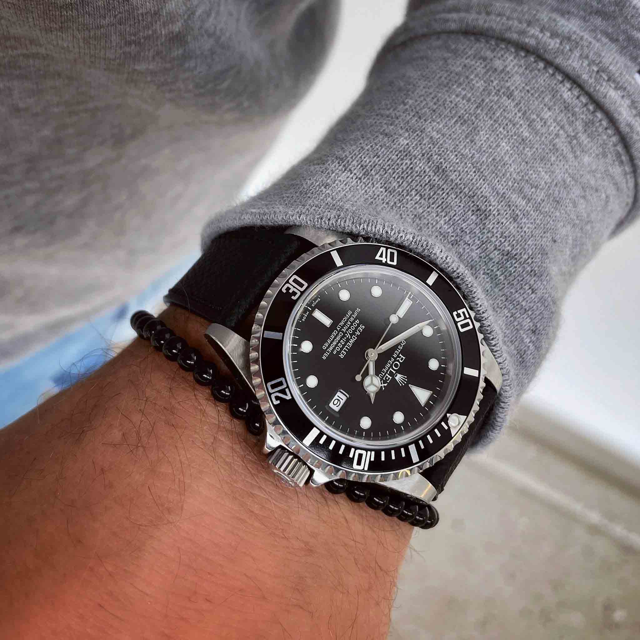 black onyx bracelet for men next to a rolex submariner