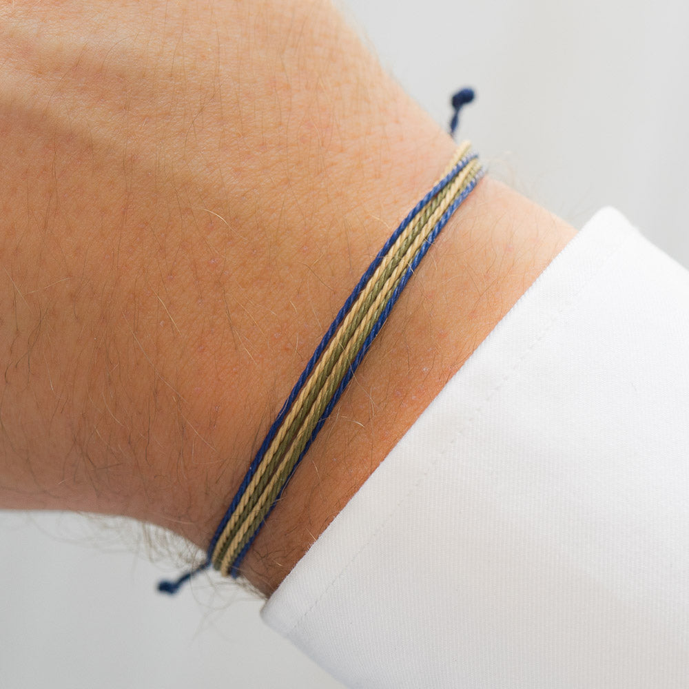 blue string bracelet on wrist with white shirt