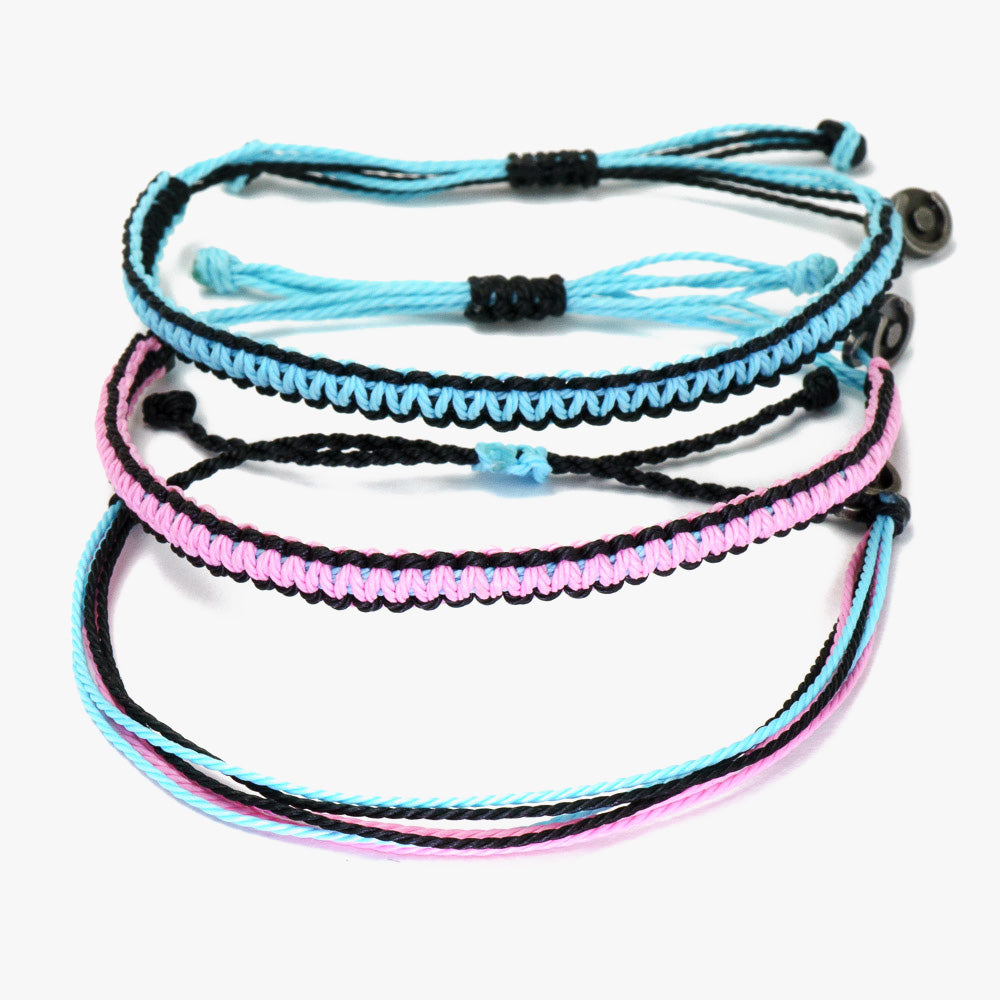 Three wax-coated polyester bracelets in black, pink, and blue colors, each featuring a gunmetal power pose charm.