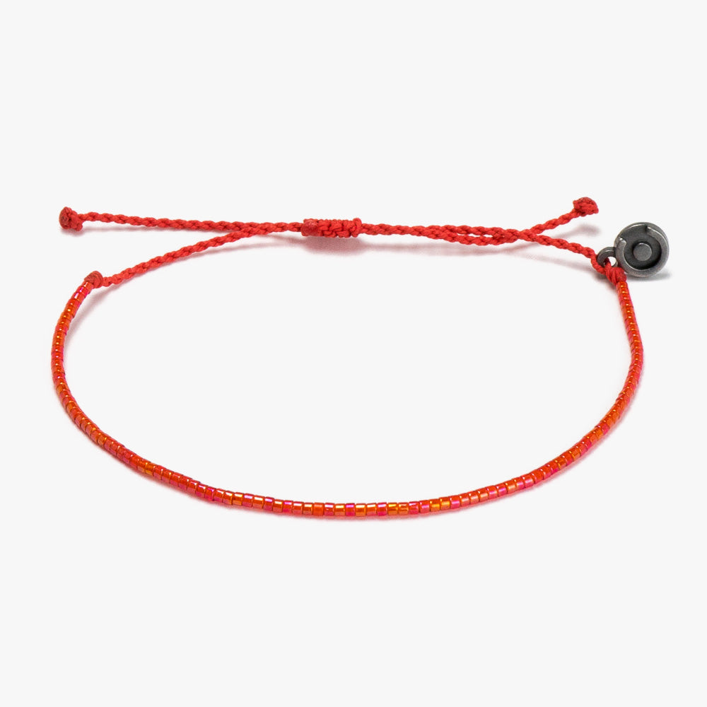A red beaded bracelet with a gunmetal power pose charm, displayed on a white background.