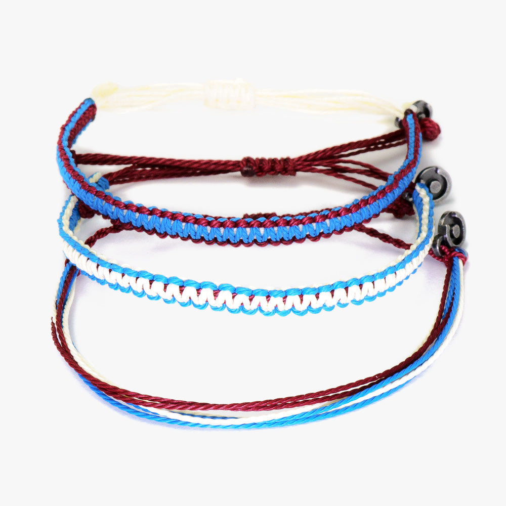 Three wax-coated polyester bracelets with gunmetal charms, displayed in a stacked arrangement with red, blue, and white colors.