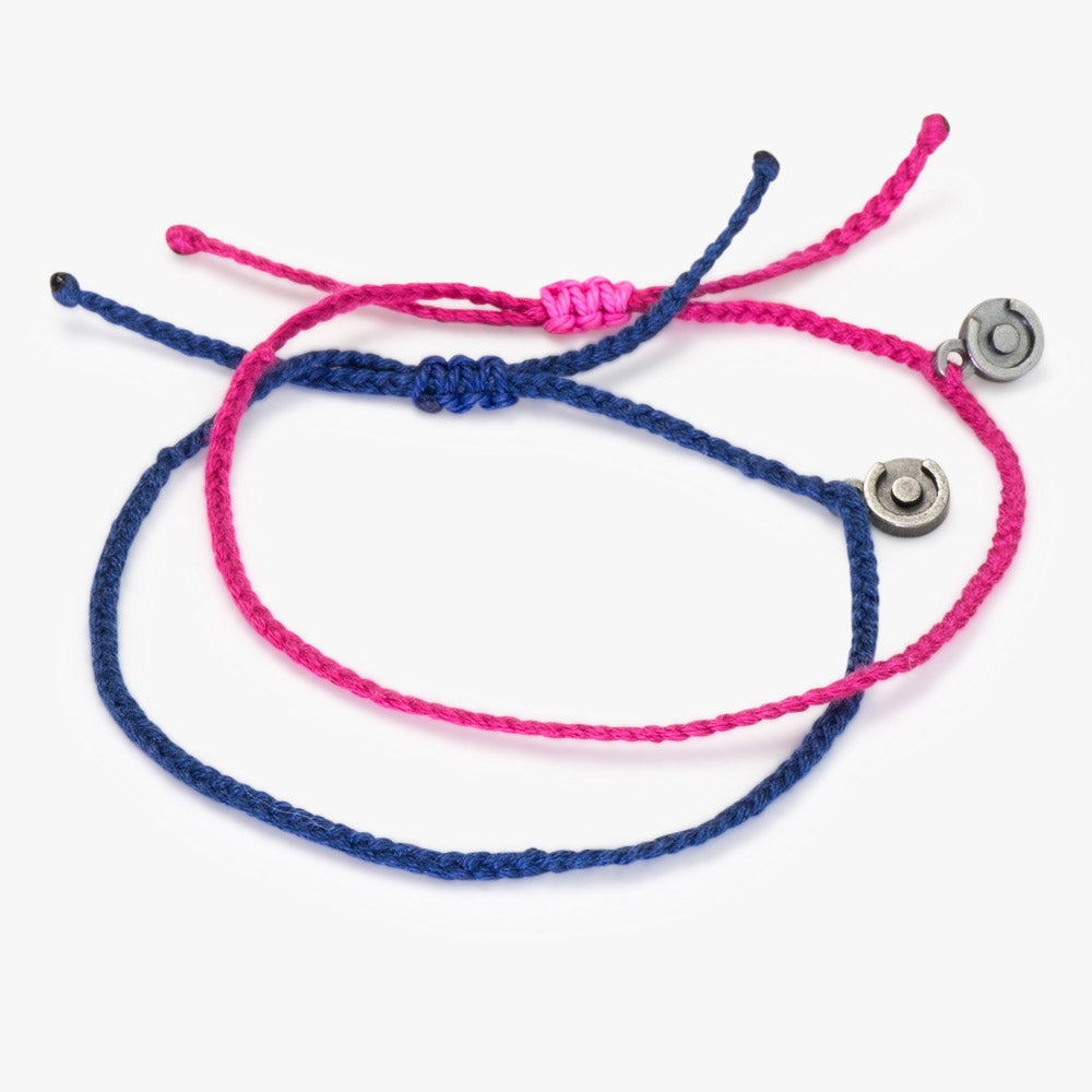 Two woven couple bracelets, one in light pink and one in light blue, with Chibuntu charms, displayed against a white background.