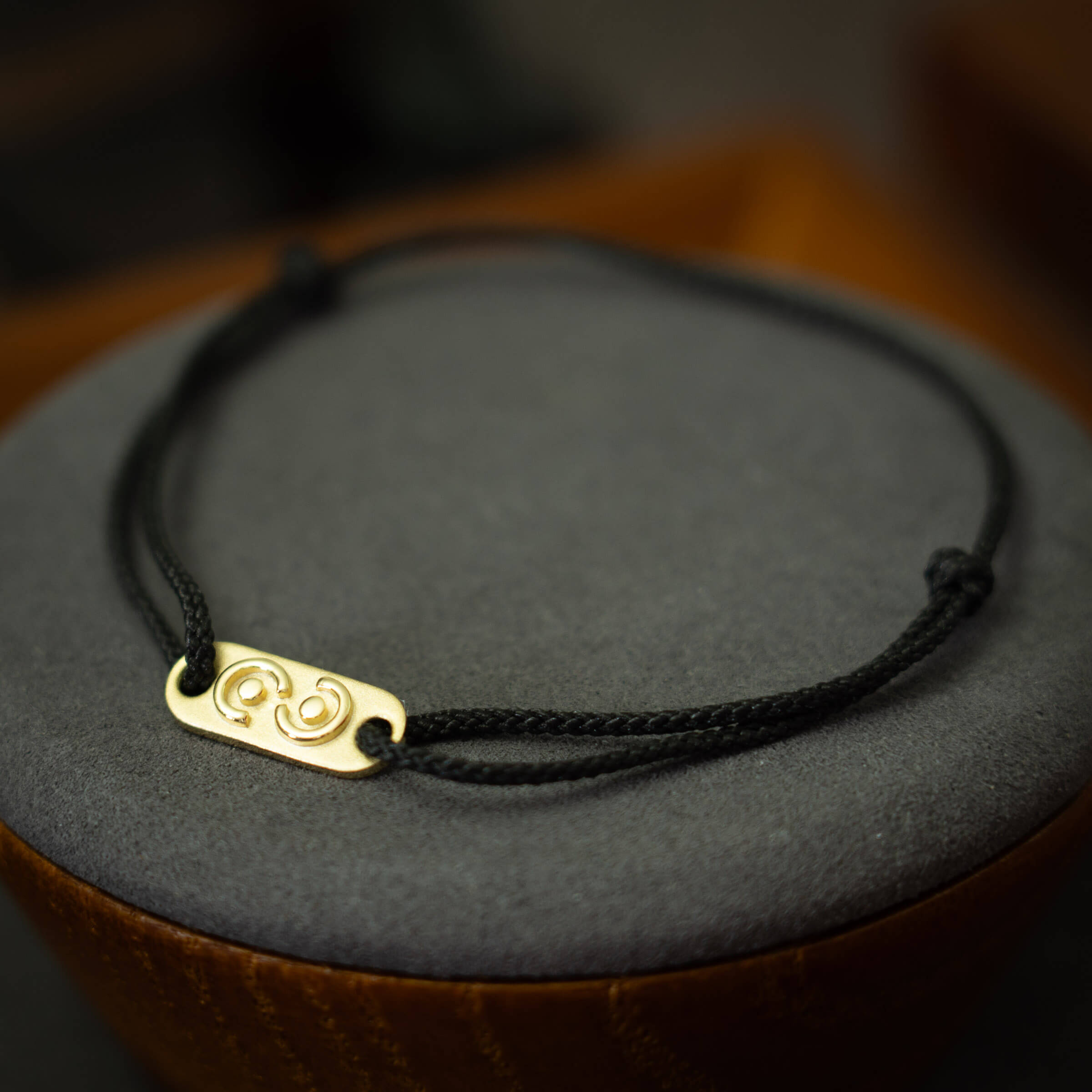 men's gold tag on black thread bracelet