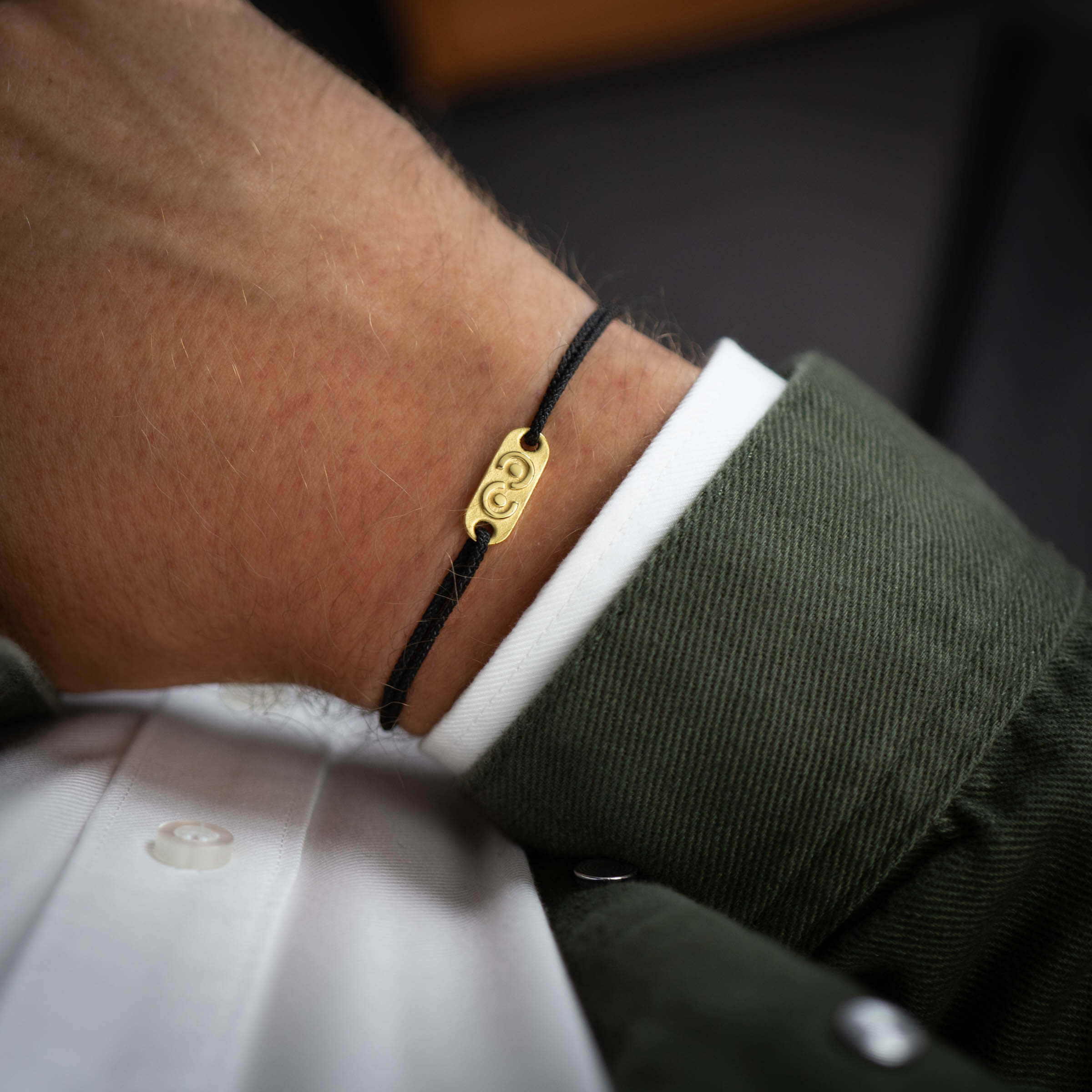 gold tag on black thread bracelet for men