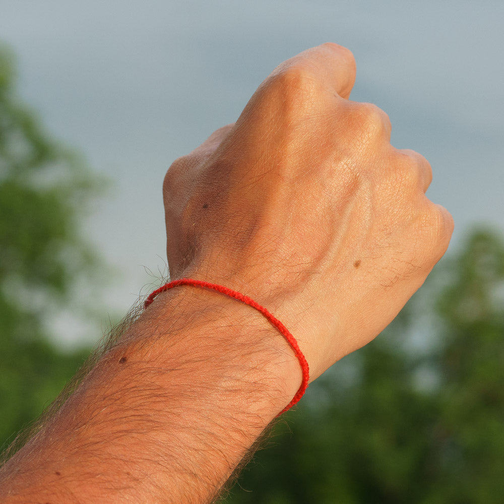 powerful handgesture by a man wearing a red bracelet