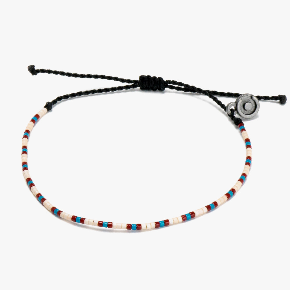 A multicolored beaded bracelet with a Chibuntu power pose charm, featuring a sliding knot closure.