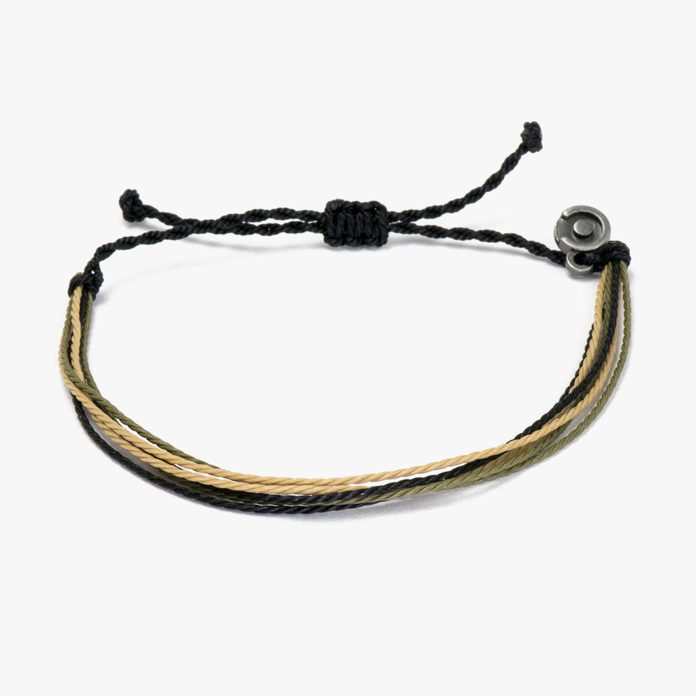A two-tone (black and beige) military string bracelet with a power pose charm, displayed on a white background.