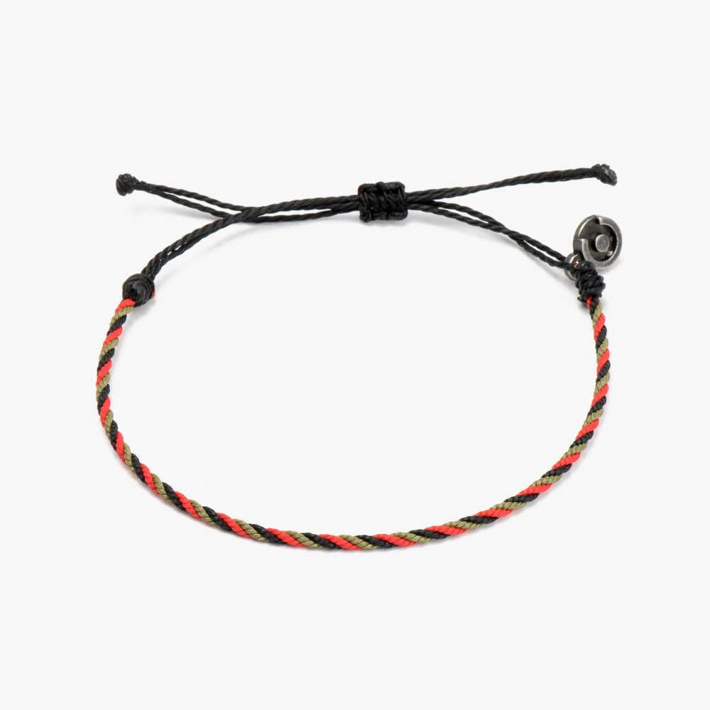 A twisted bracelet with red, black, and green strands, featuring a gunmetal charm, displayed against a white background.